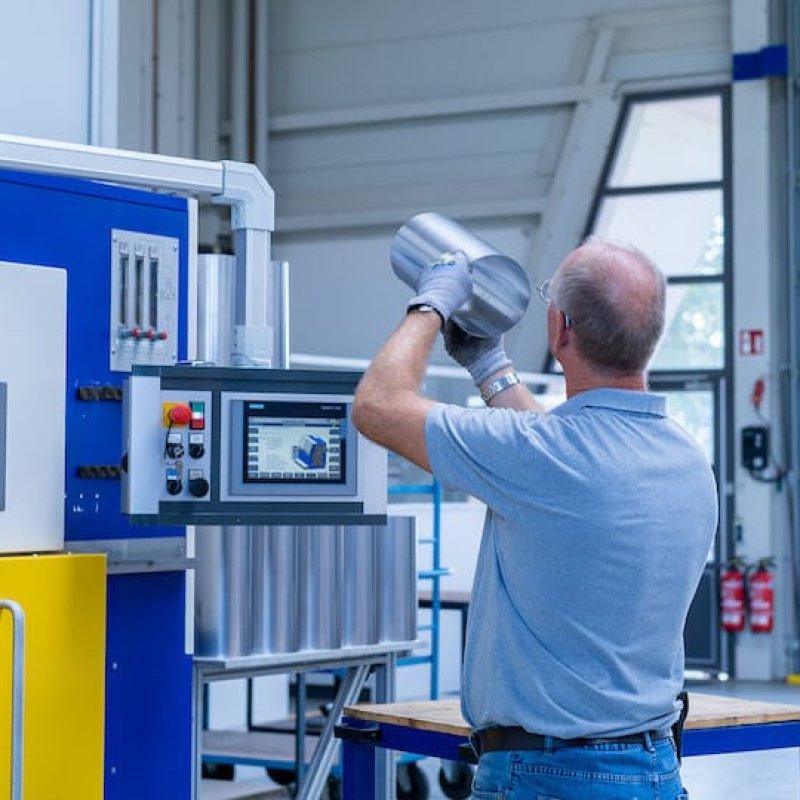 Mitarbeiter bei der Sichtung eines Blechrohre vor der Laserschweißmaschine